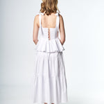 Woman wearing a white dress with a cut-out back design on a white background